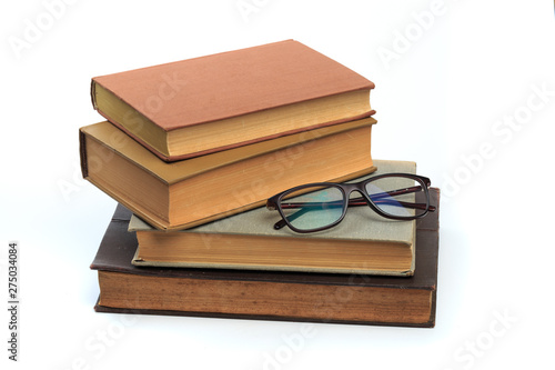 vintage old hardcover books with glasses on white background