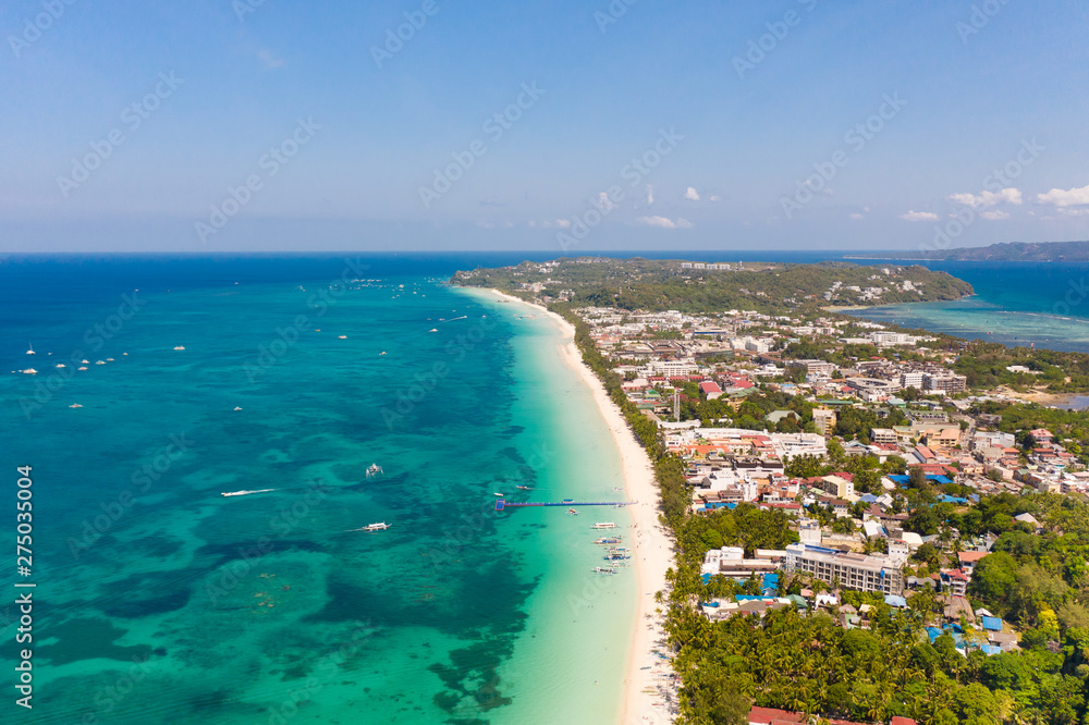 The coast of the island of Boracay. White beach and clear sea. Seascape with a beautiful coast in sunny weather. Residential neighborhoods and hotels on the island of Boracay, Philippines, view from