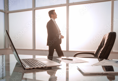 Businessman standing and looking out the window in the conference room