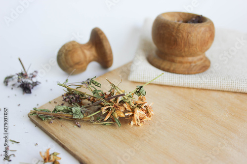  Herbal tea made from Hypericum and Oregano on a wooden board, wooden spoon and wooden bamboo mortar