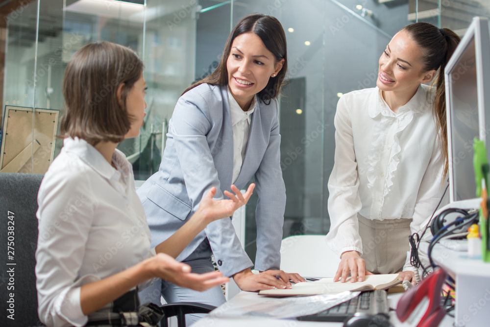 Group of three beautiful business women discussing project at brainstorming meeting in office Group of three beautiful business women discussing project at brainstorming meeting in office