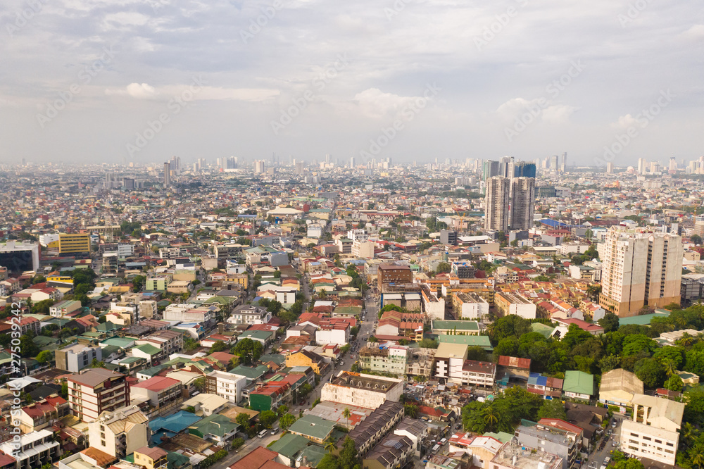 Residential areas and streets of Manila, Philippines, top view. Roofs of houses and roads. Philippine capital.