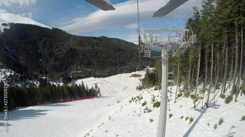 POV backwards to black Tomba slope from skier riding on ski lift in Bansko Bulgaria photo