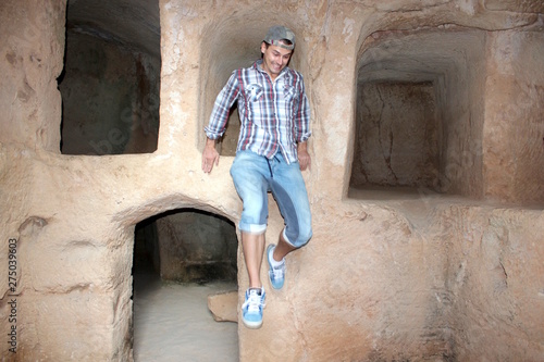 A young man jumps down from the ancient wall