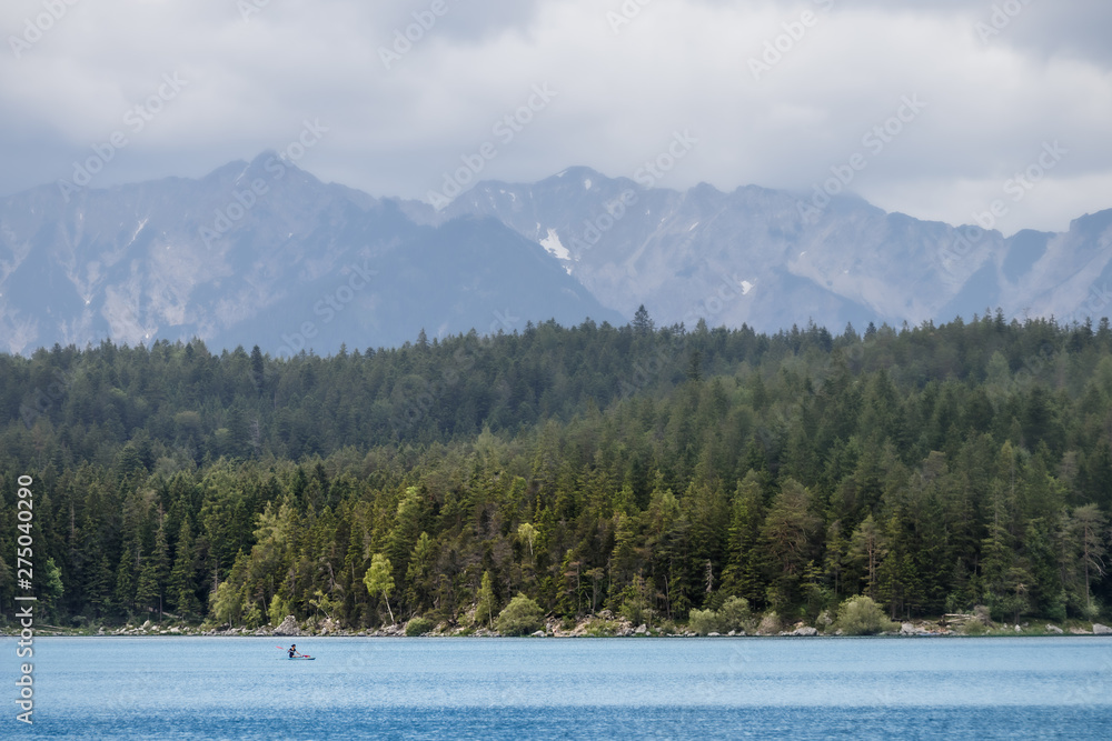 Φωτογραφία Unrecognizable woman rowing a small boat on a lake in the European Alps on a sum