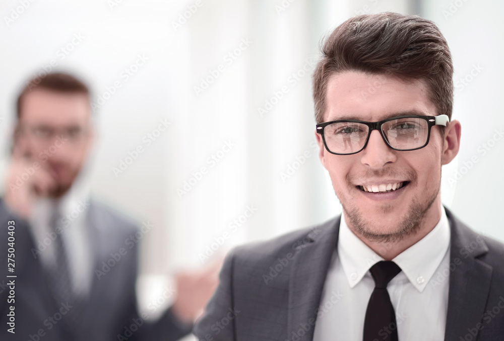close up.smiling young businessman in the office background close up.smiling young businessman in the office background