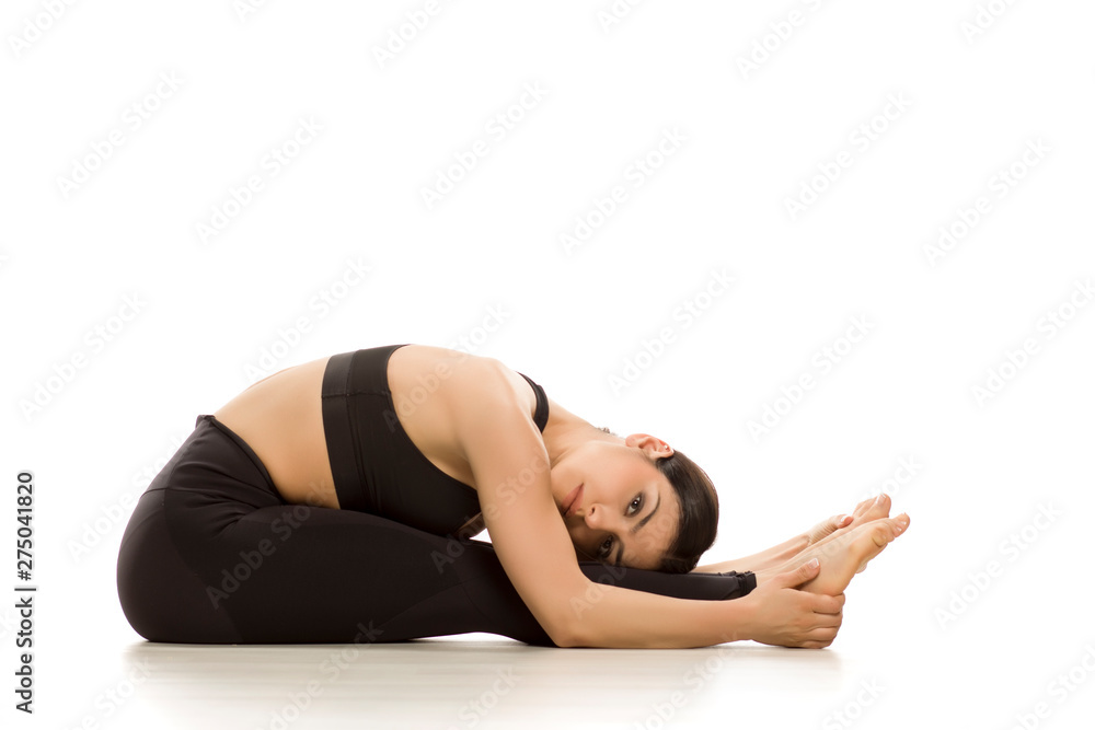 Flexible yoga woman doing yoga seated forward bend pose isolated on white background Flexible yoga woman doing yoga seated forward bend pose isolated on white background