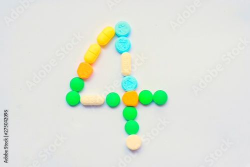 Various color pills Placed in numbers on a white background