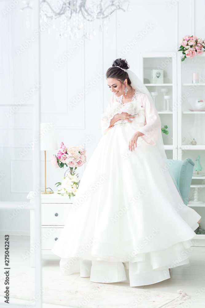 Happy morning of the bride. Girl admires her wedding dress. Beautiful Bride boudoir Happy morning of the bride. Girl admires her wedding dress. Beautiful Bride boudoir