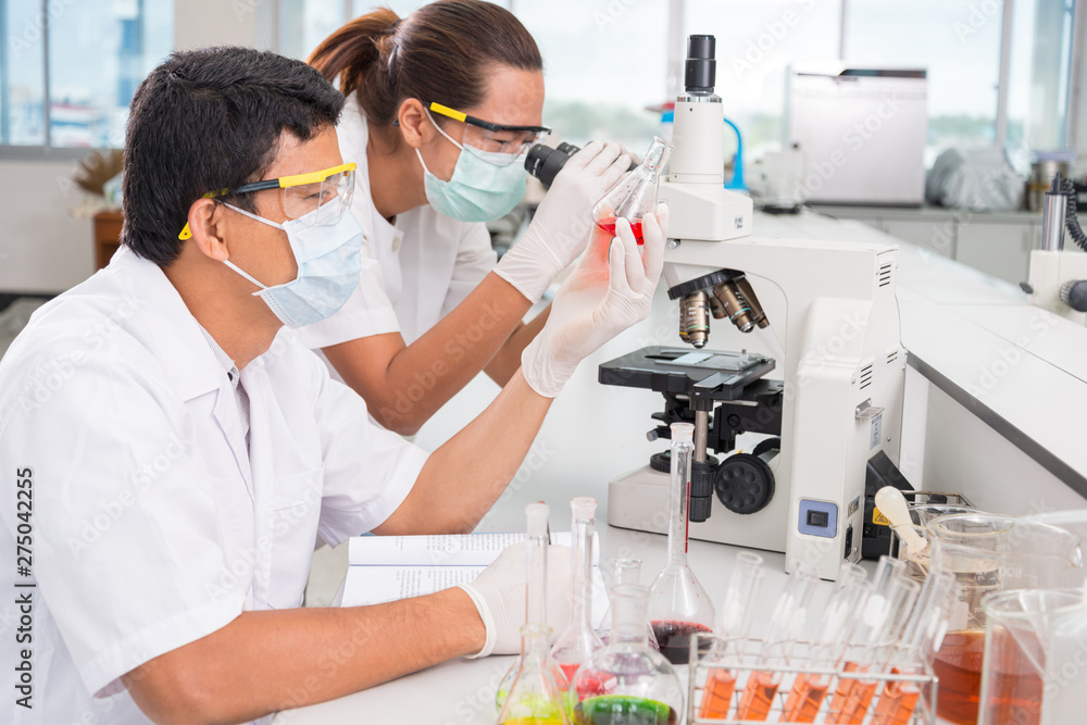 Serious clinician studying chemical element on tester Serious clinician studying chemical element on tester