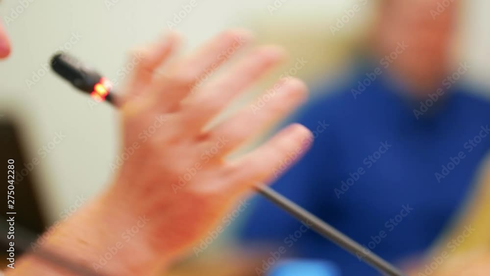 A male politician speaking into the microphone and actively gesticulating A male politician speaking into the microphone and actively gesticulating