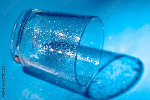 A glass with water drops  on a dark blue background close up