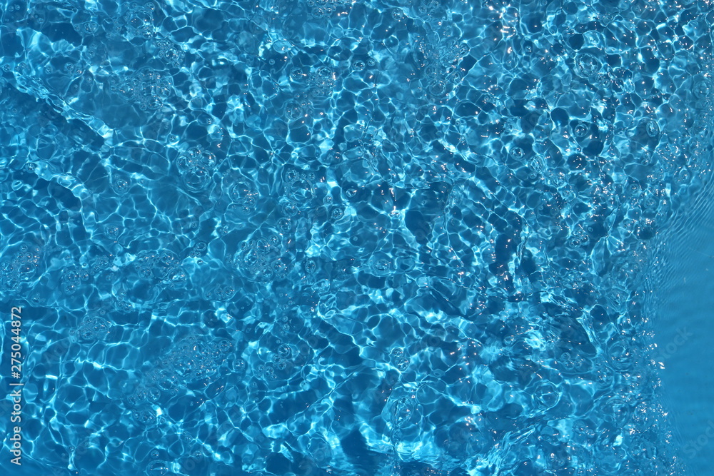 Blue and bright water surface with sun refection in swimming pool for background Blue and bright water surface with sun refection in swimming pool for background