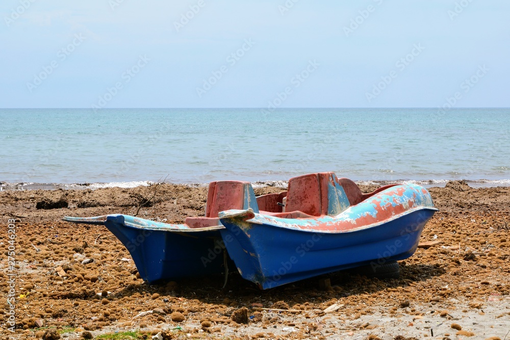 Old, rusty pedal boat with dilapidated paint. Broken pedalo on the seashore. Durres, Albania Old, rusty pedal boat with dilapidated paint. Broken pedalo on the seashore. Durres, Albania