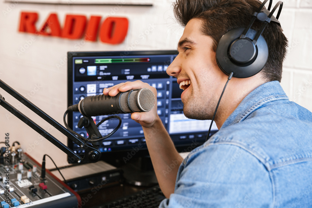 Handsome happy young male radio host broadcasting Photos | Adobe Stock