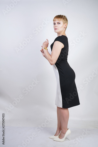 Obraz na plátně beautiful plus size blonde girl with short hair in a fashionable office dress on a white background in the Studio