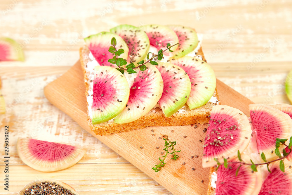 Healthy breakfast toasts from sliced watermelon radish or chinese daikon, chia and cottage cheese on board wooden background. Copy space. Healthy breakfast toasts from sliced watermelon radish or chinese daikon, chia and cottage cheese on board wooden background. Copy space.