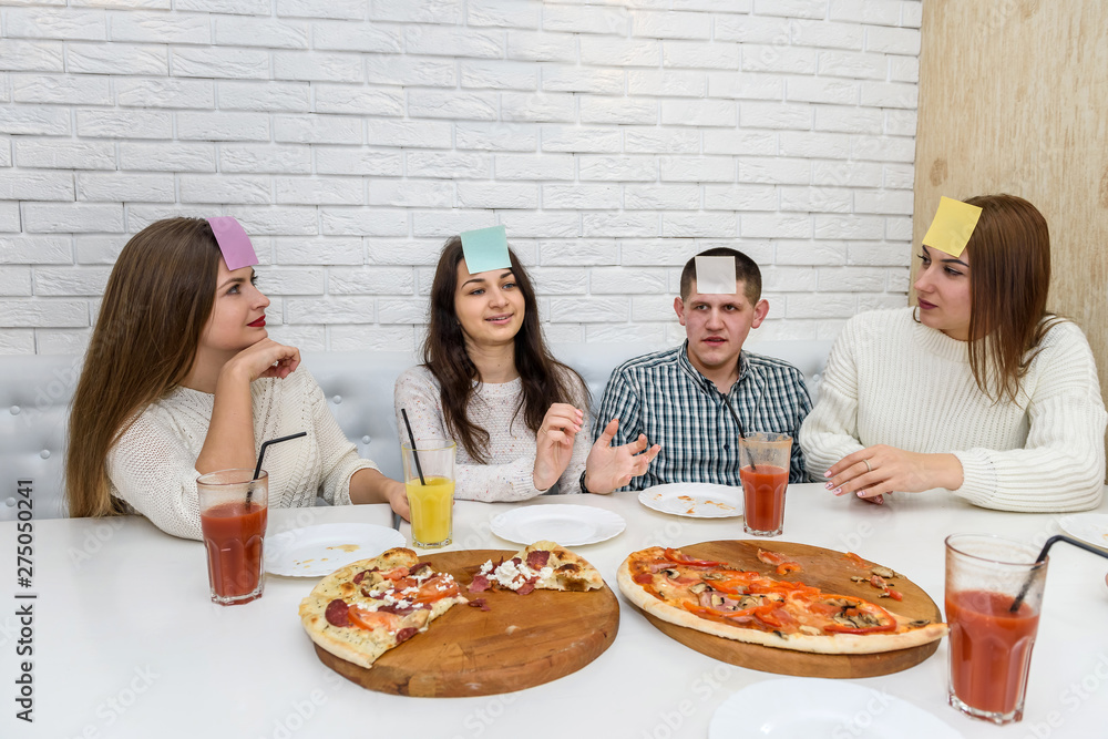Friends in cafe eating pizza and posing for camera Friends in cafe eating pizza and posing for camera