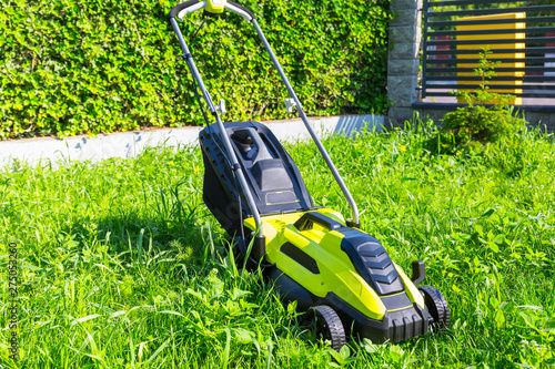 Lawn mower before cutting green grass in backyard