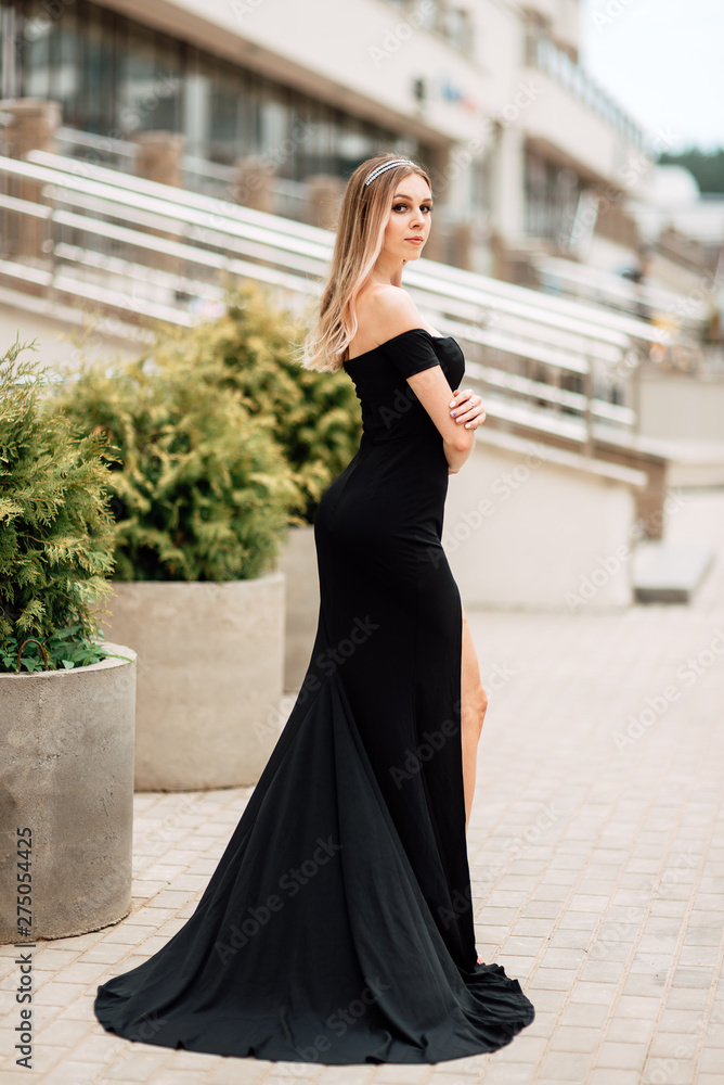 beautiful young girl in black dress walking the streets of the city, the woman is resting outdoors, street fashion. urban lifestyle. beautiful young girl in black dress walking the streets of the city, the woman is resting outdoors, street fashion. urban lifestyle.
