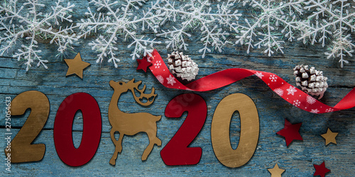 New year concept. Digits 2020 on wooden background with Christmas decoration