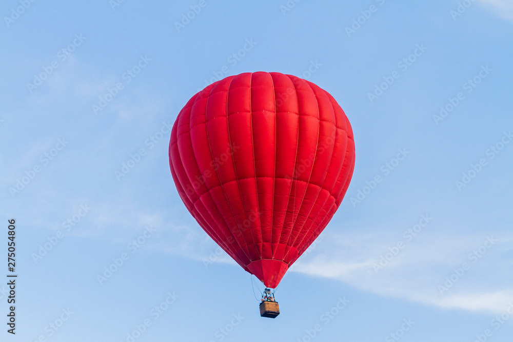 Naklejka premium red air balloon flies across the blue sky
