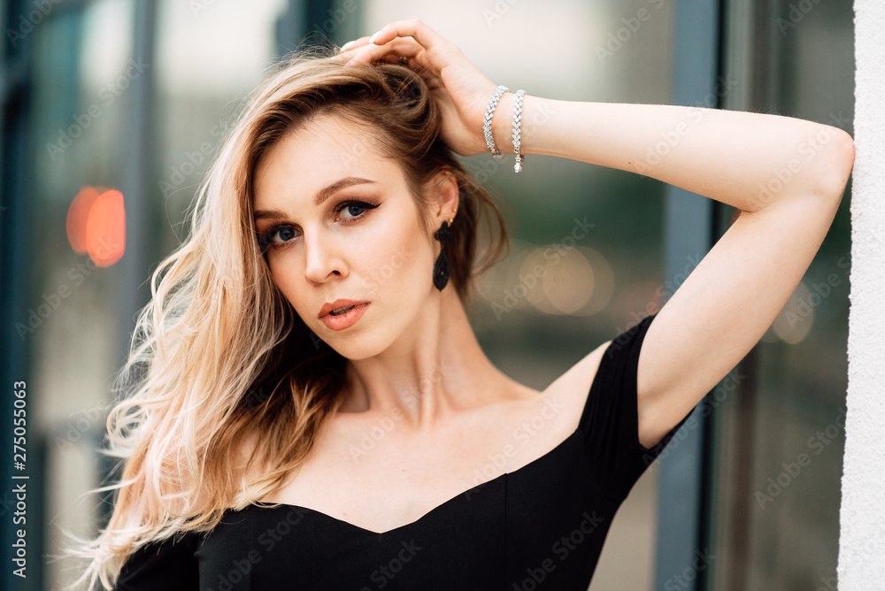 portrait of beautiful young girl in black dress outdoors