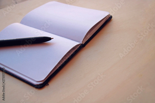 White background with a notebook and a black pen.