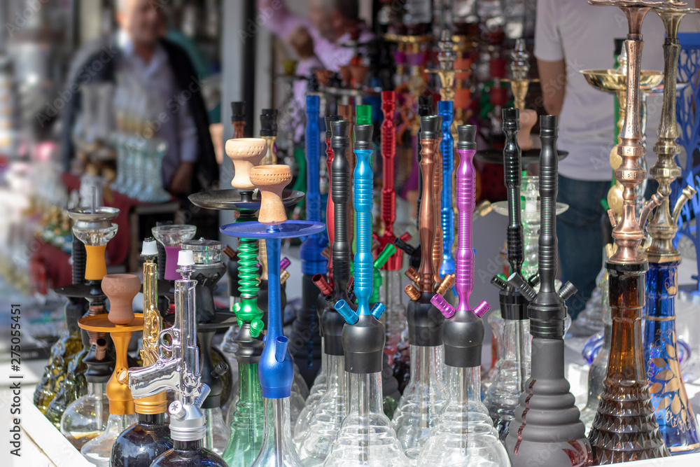 Traditional hookah machines. Stands on the shelf in different colors and patterns. Photographed in front of the store.
