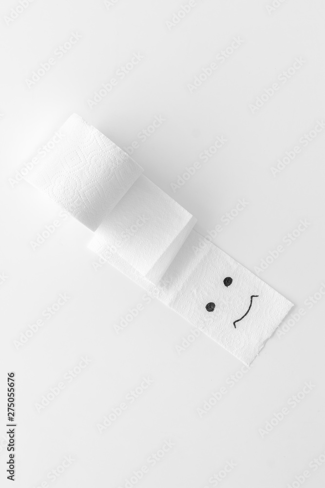 Proctology concept with toilet paper roll and painted face on white background top view Proctology concept with toilet paper roll and painted face on white background top view