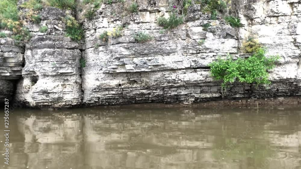 The cliffs of the canyon rise above the river. Rocky mountain cliff on the banks of the Dniester Rivere The cliffs of the canyon rise above the river. Rocky mountain cliff on the banks of the Dniester Rivere