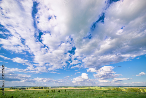 Photography View of agricultural field with white fluffy clouds in blue sky at sunny summer