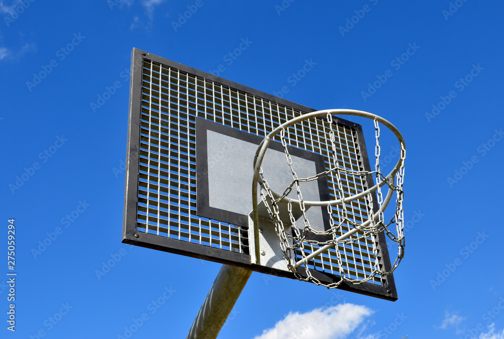 Basketball rim, streetball hoop against blue sky.