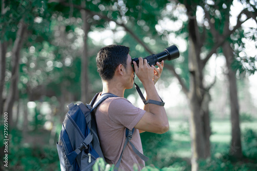 Young photographer holding camera take photo in forest