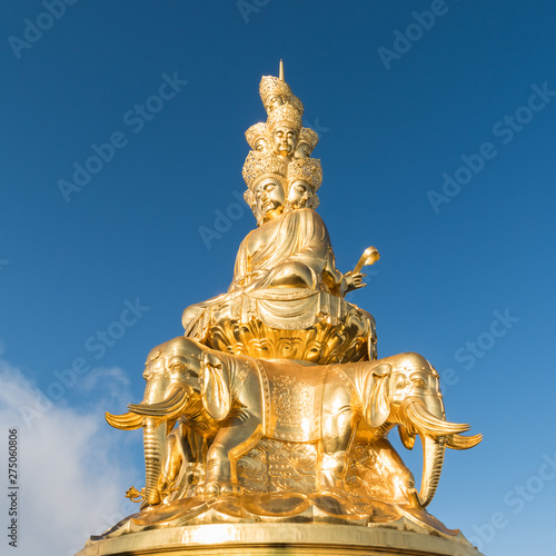 gold buddha against a blue sky