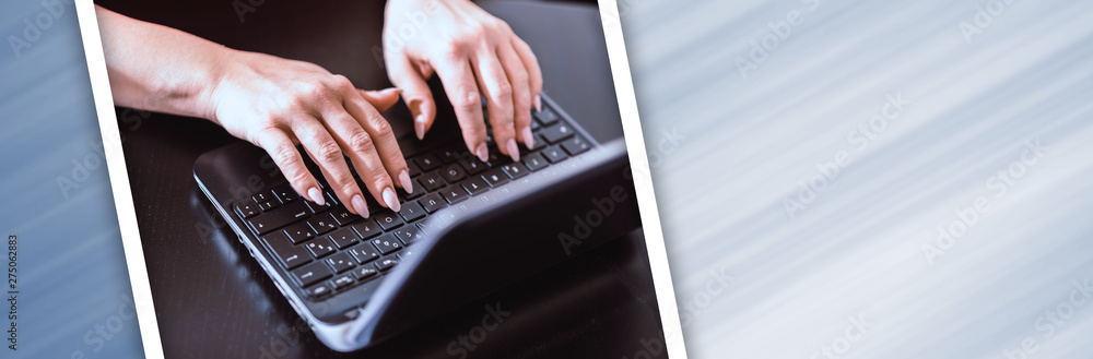 Female hands typing on laptop; panoramic banner Female hands typing on laptop; panoramic banner