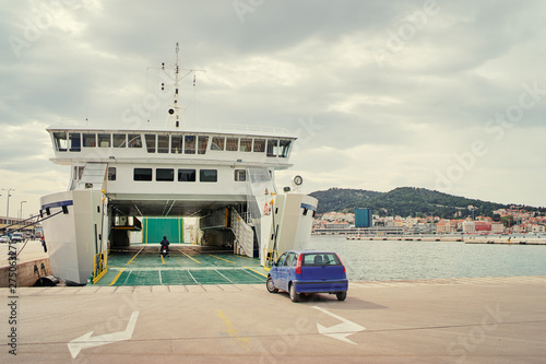 Ferryboat loading or unloading by a port pier. Concept of transportation and traveling.