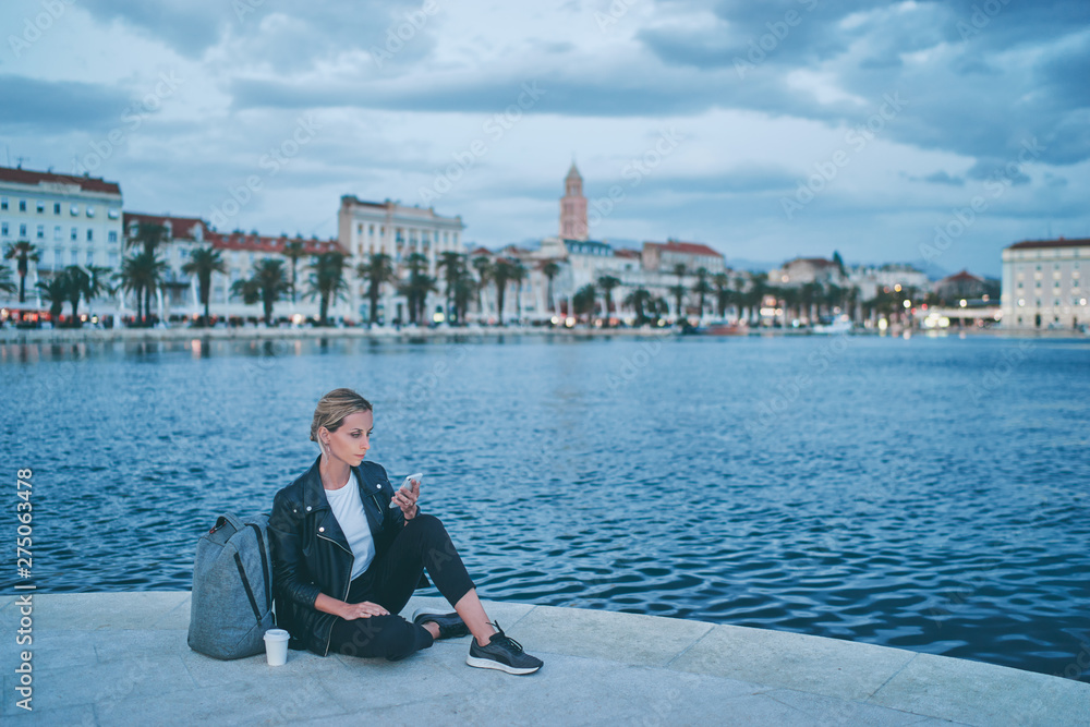 Vacation in Split. Young traveling woman using smartphone on seaside promenade with city view. Vacation in Split. Young traveling woman using smartphone on seaside promenade with city view.