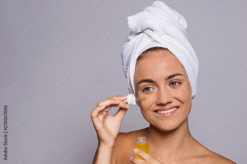 Portrait of a young woman applying hyaluronic acid in a studio. Portrait of a young woman applying hyaluronic acid in a studio.