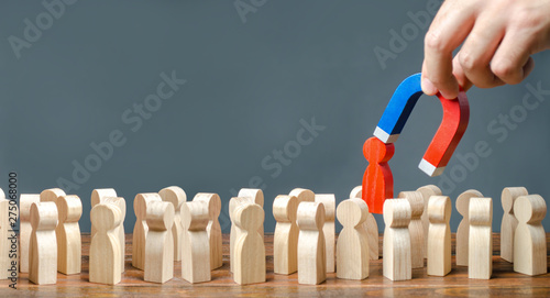 Εκτύπωση καμβά A hand with a magnet pulls a red human figure out of the crowd