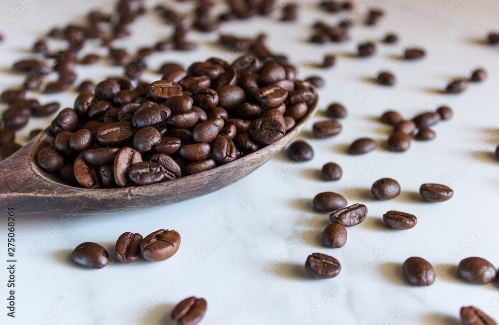 Naklejka premium Fresh roasted coffee beans. On the marble floor.