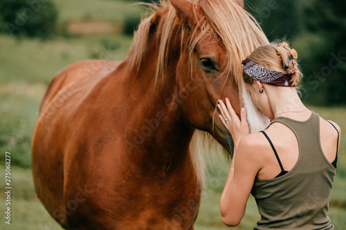 Young beautiful girl hugging horse at nature. Horse lover.