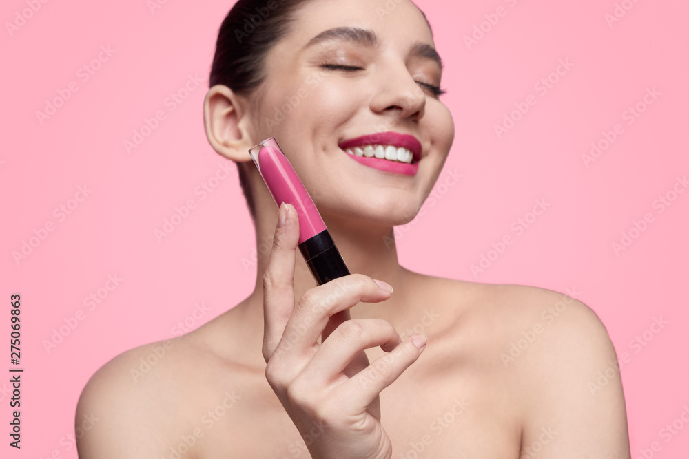 Smiling woman showing liquid lipstick Smiling woman showing liquid lipstick