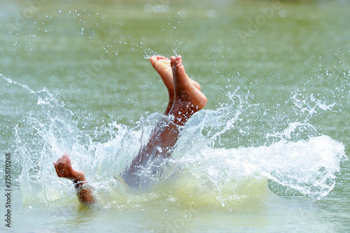 Asian children feet jumping into the water.