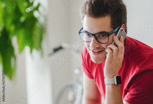 A boy speaks by phone at home photo