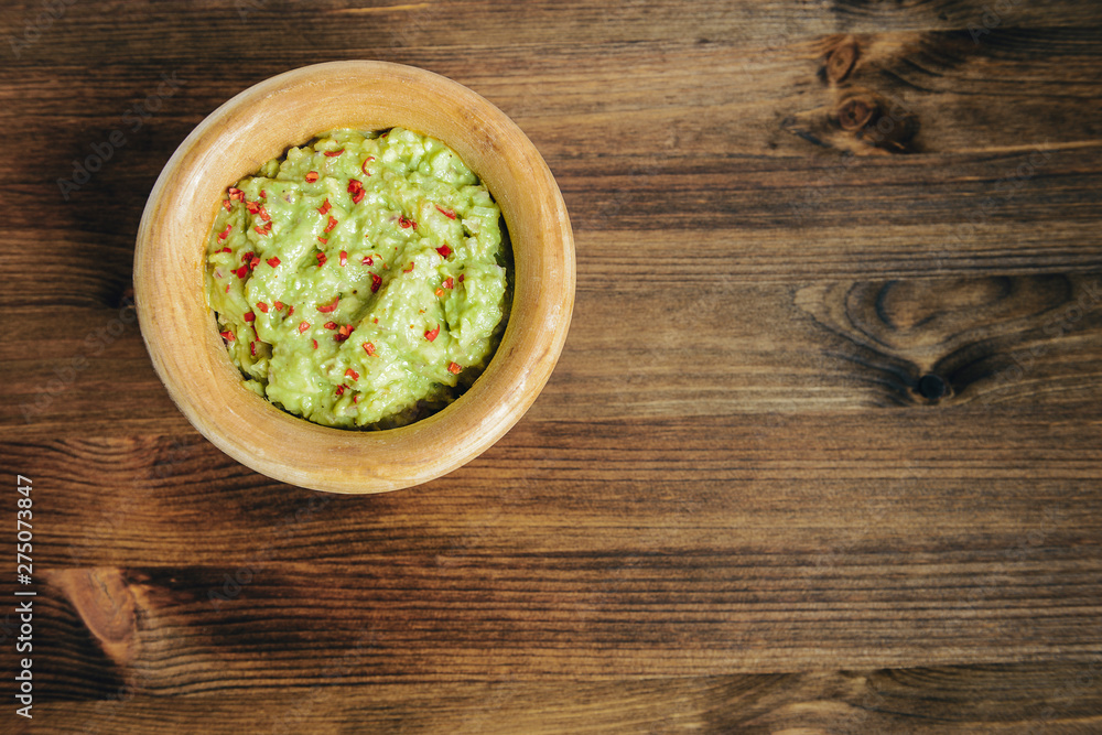 bowl of mexican guacamole on a wooden table bowl of mexican guacamole on a wooden table