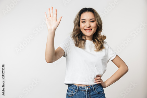 Portrait of a lovely young asian woman standing isolated