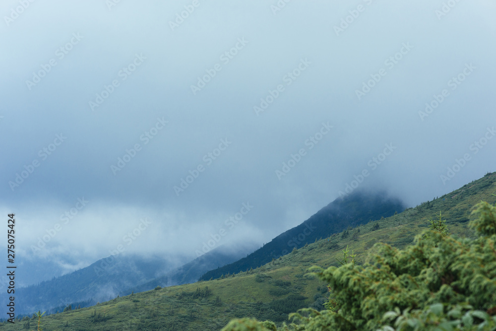 Green mountain landscape against cloudy sky