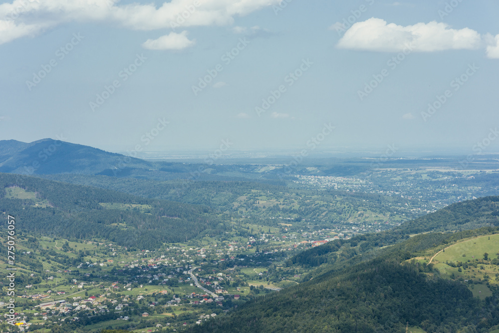 Aerial view of green mountain valley with town