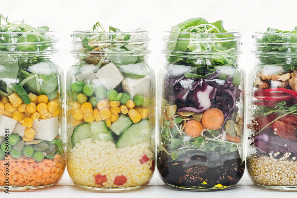 fresh vegetable salad in glass jars isolated on white fresh vegetable salad in glass jars isolated on white